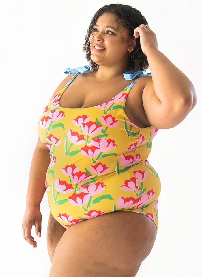 Photo of a woman wearing a Claus shoulder-tie one-piece swim suit side angle