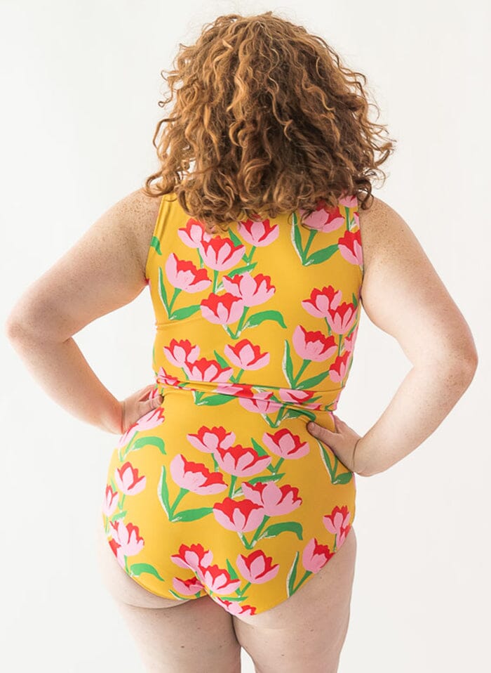 Photo of a woman wearing a Claus swim crop top and a Claus swim bottom back angle