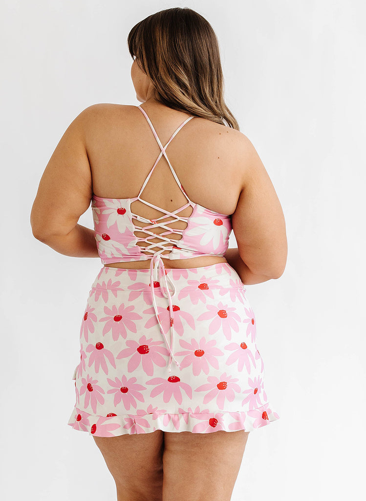 Photo of woman wearing pink floral lace back swim top with pink floral swim skirt back angle
