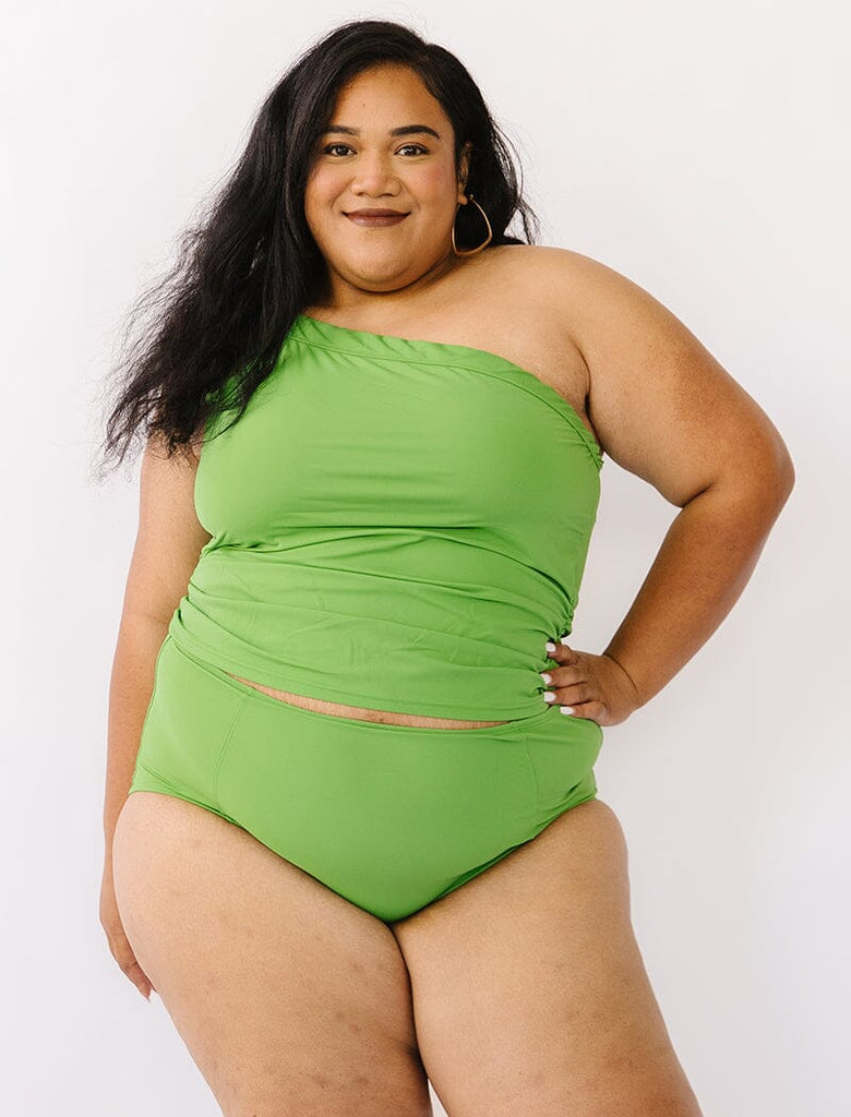 Photo of woman wearing green one shoulder tankini swim top with green swim bottoms