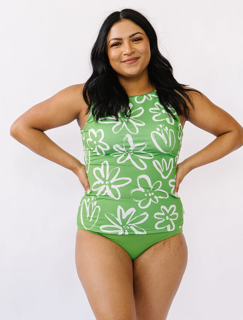 Photo of woman wearing a green and white floral boat neck tankini swim top with green swim bottoms