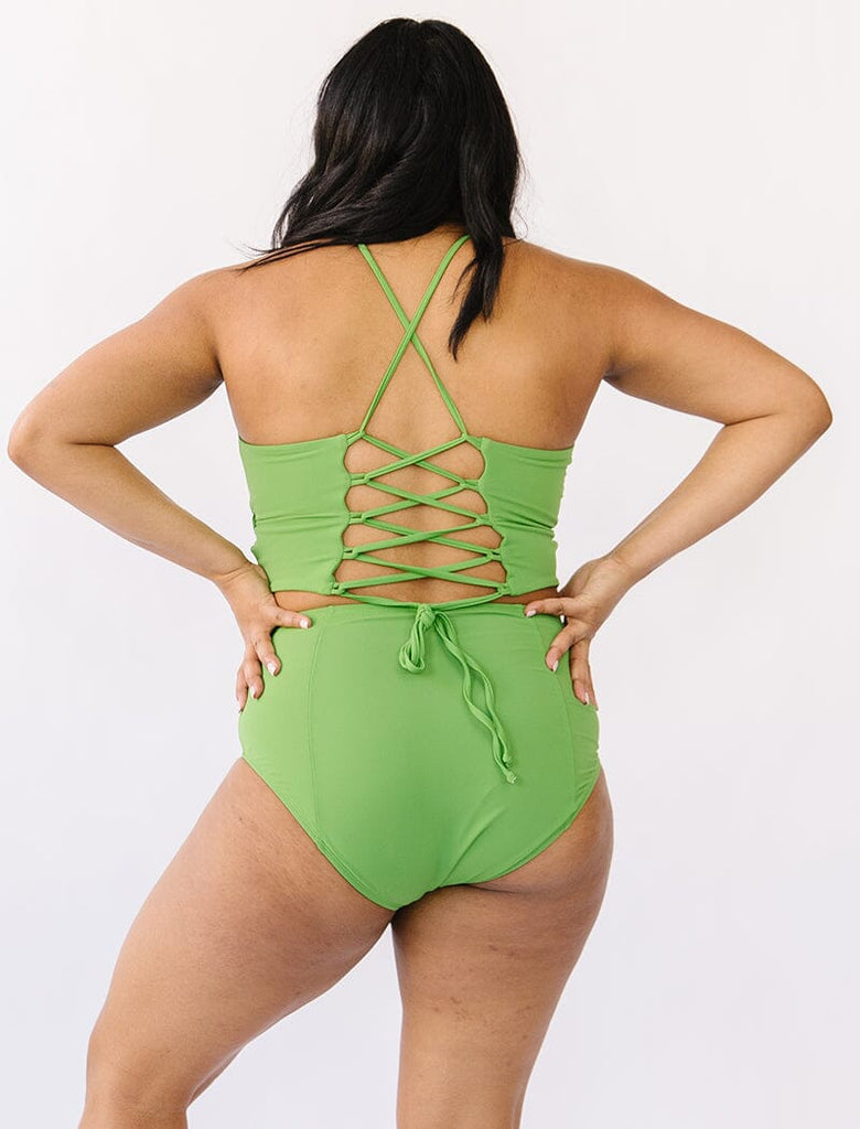 Photo of woman wearing green cropped lace back swim top with green swim bottoms back angle