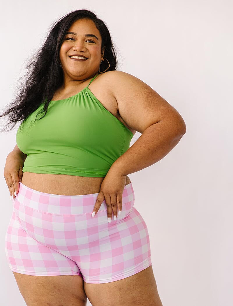 Photo of woman wearing green lace back swim top with pink gingham swim shorts