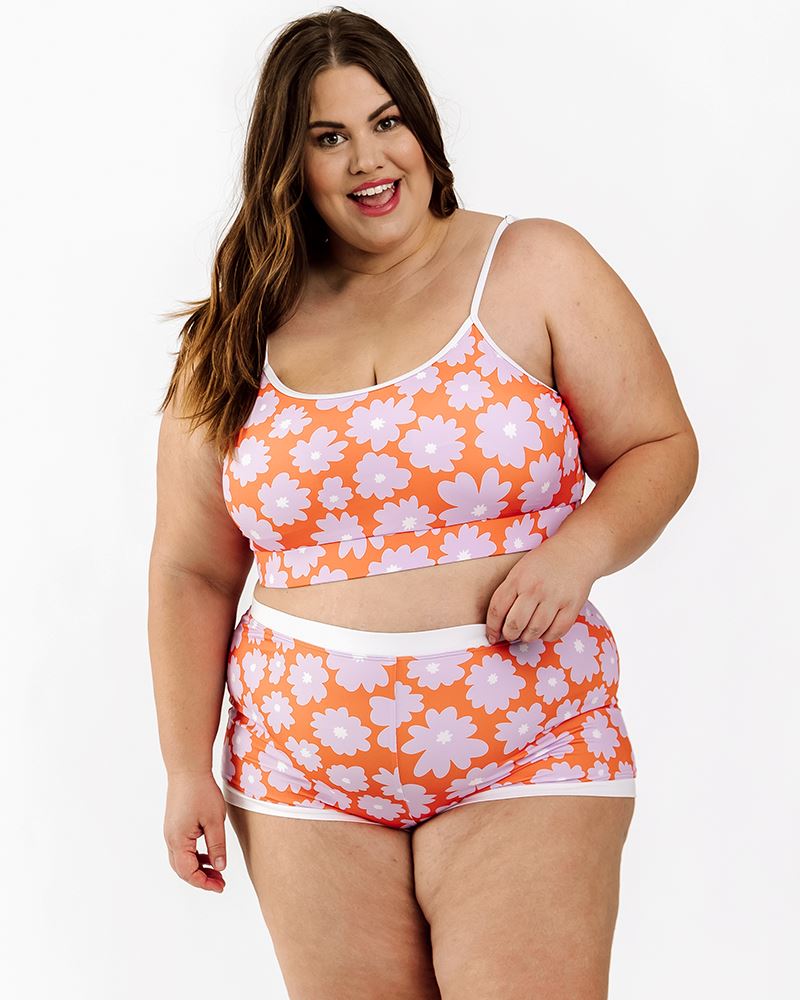 Photo of a woman wearing a Daphne floral swim bralette and a Daphne floral swim short bottom