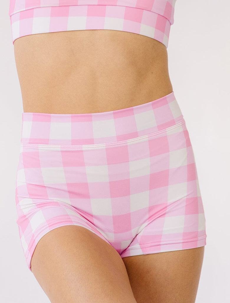 Photo of woman wearing pink gingham swim shorts