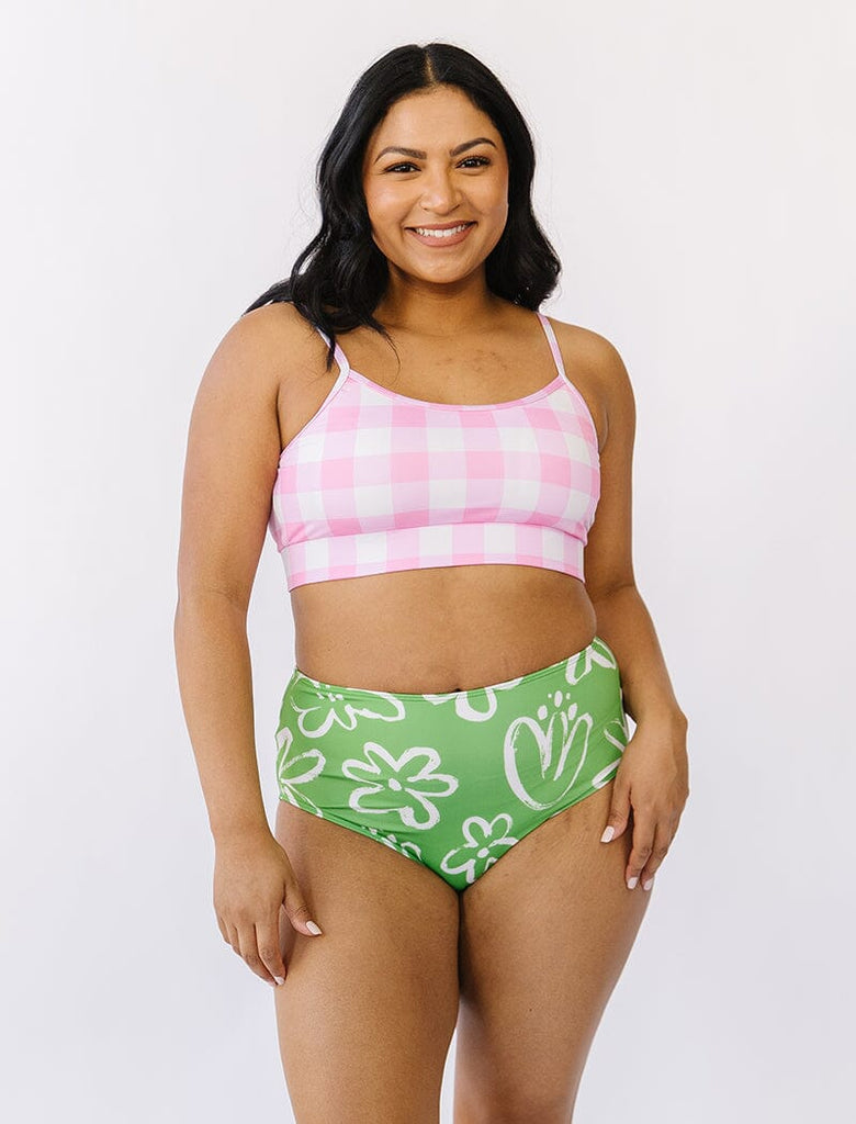 Photo of woman wearing pink gingham bralette swim top with green and white floral swim bottoms