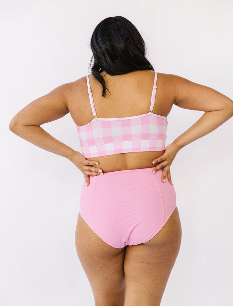 Photo of woman wearing pink gingham bralette swim top with pink swim bottoms back angle