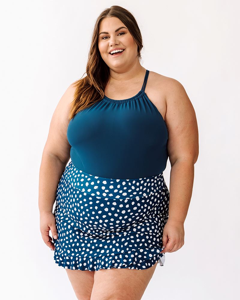Photo of a woman wearing an Indigo double-cinch swim top and an indigo dot swim skirt bottom