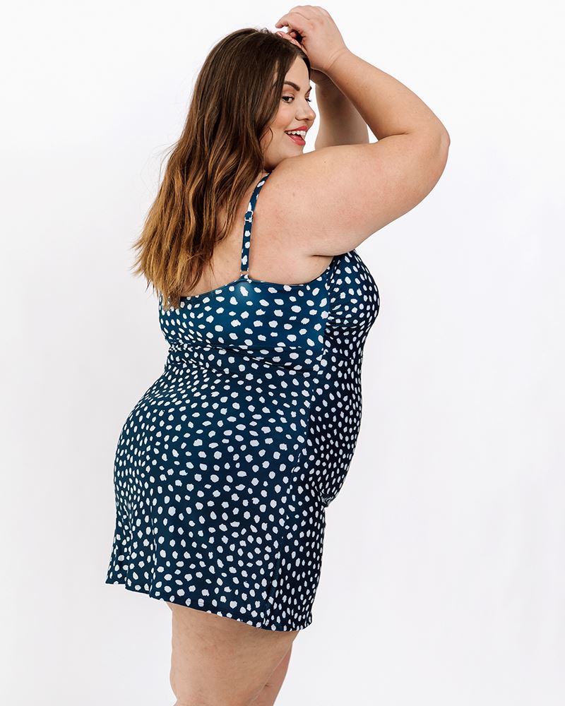 Photo of a woman wearing an Indigo dot swim dress one-piece side angle