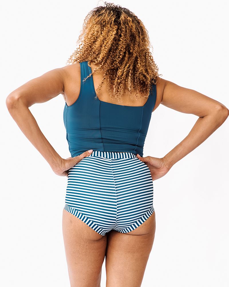 Photo of a woman wearing an Indigo retro swim short bottom and an Indigo square neck swim crop top back angle