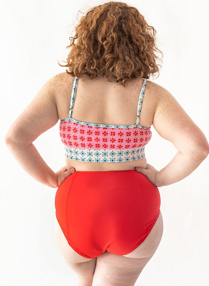 Photo of a woman wearing a pink Margrethe swim Bralette and a red swim bottom back angle