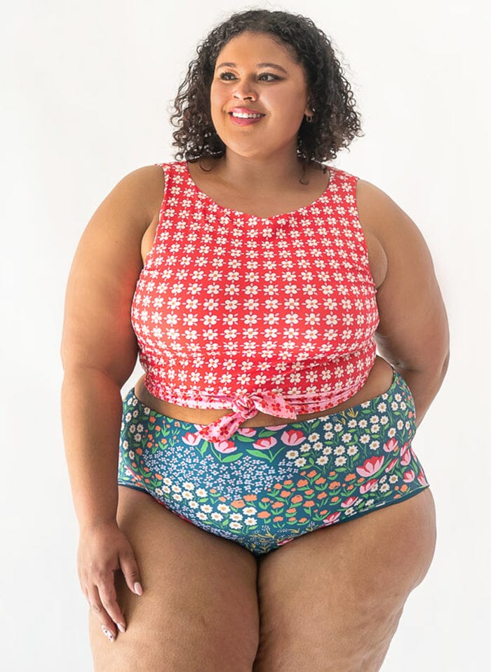 Photo of a woman wearing a red floral cropped swim top with blue floral high waist swim bottoms