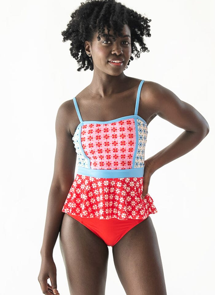 Photo of a woman wearing a Pink Margrethe peplum swim top and a red swim bottom