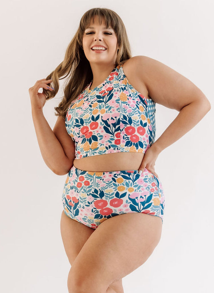 Photo of a woman wearing a May Flowers cross-back swim crop top and a may flowers swim bottom