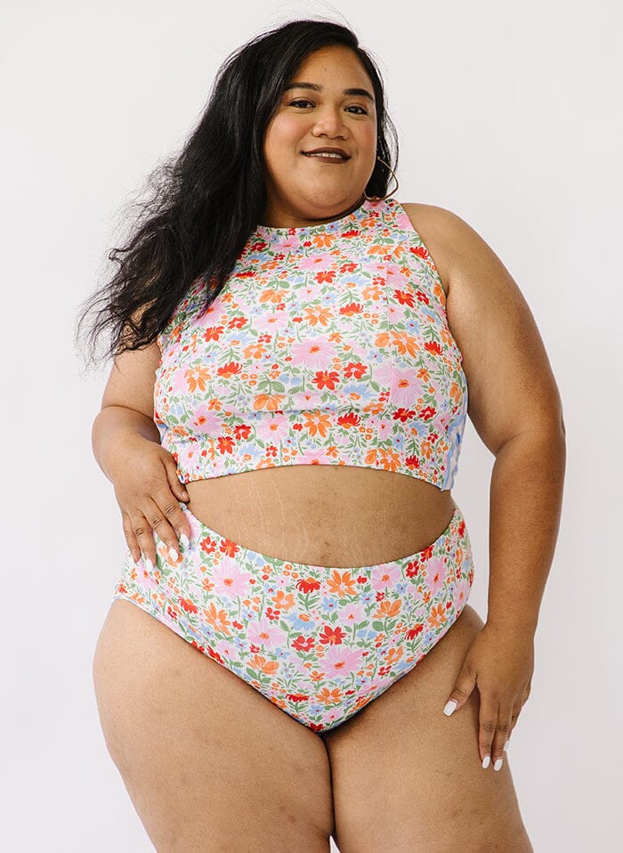 Photo of a woman wearing a multi color swim crop top and floral swim bottoms