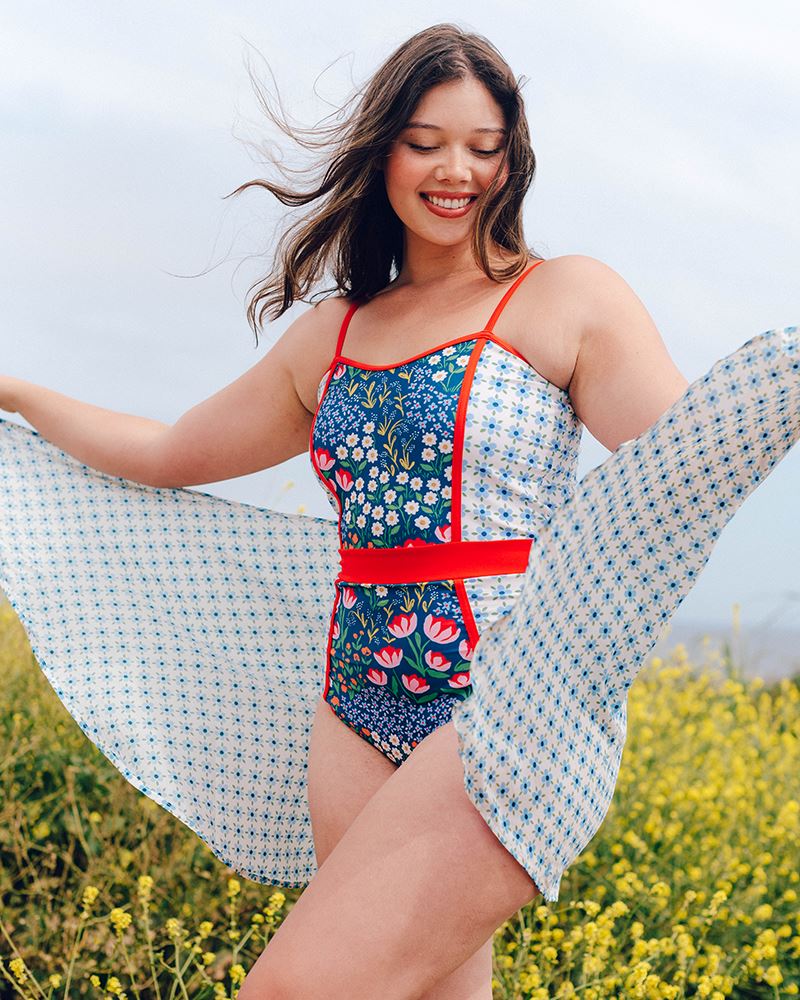 Photo of a woman wearing a light blue floral sarong and a multi color floral swim suit