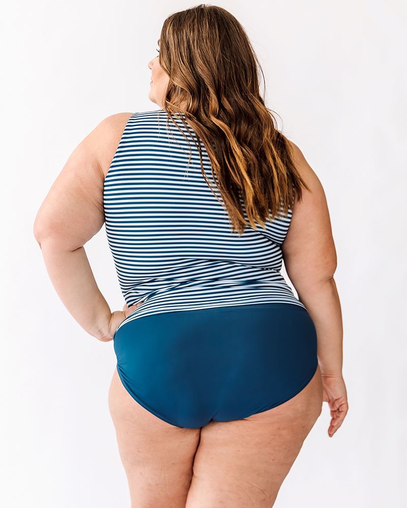 Photo of a woman wearing an Indigo stripe boat-neck swim top and an Indigo swim bottom back angle