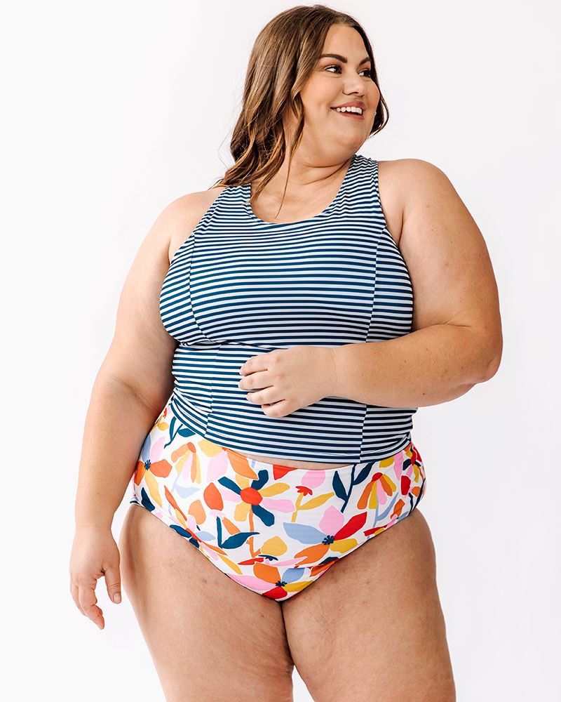 Photo of a woman wearing a June floral/ Indigo stripe reversible swim bottom floral side and an Indigo stripe swim crop top