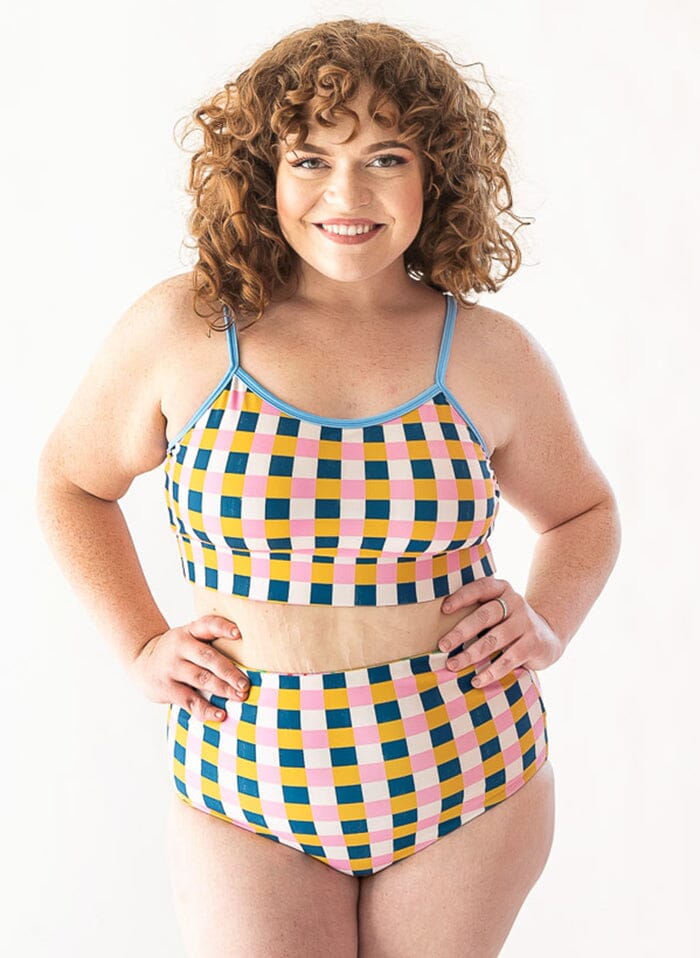 Photo of a woman wearing a Claus/Tage reversible swim bottom checkered side and a tage swim bralette