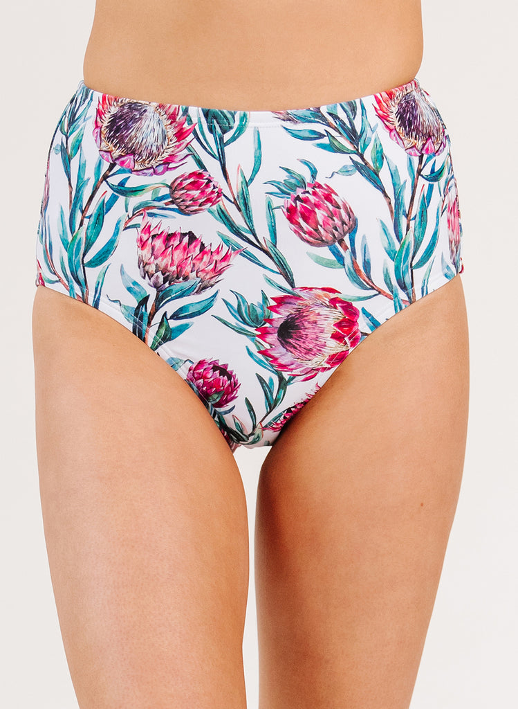 Close up photo of woman wearing a blue and pink floral high waist swim bottom