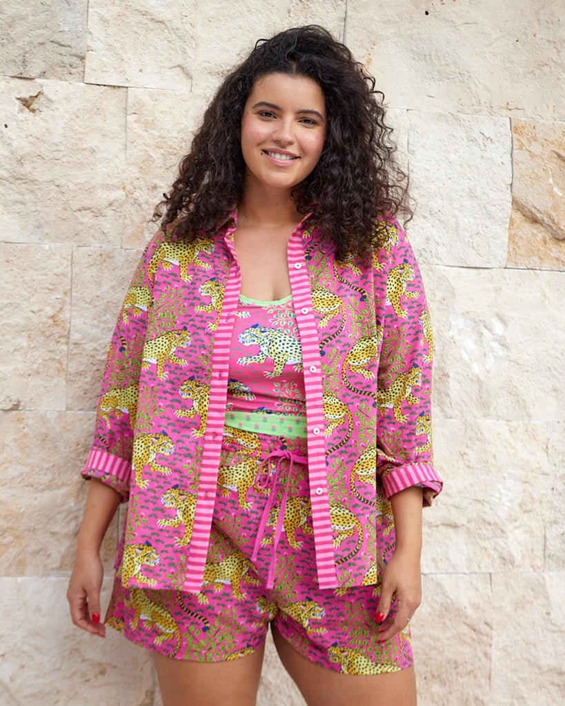Photo of a woman wearing a bold pink print featuring tigers button down two-piece swim suit cover-up set