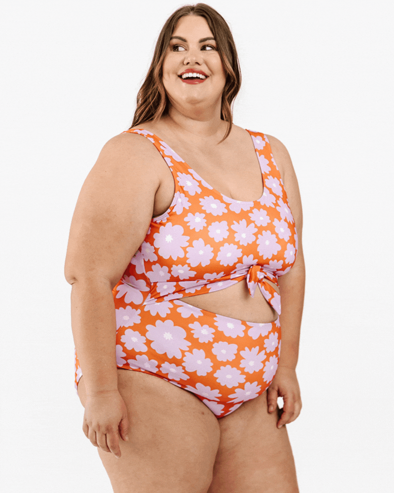 GIF of a woman wearing a Daphne floral knotted one-piece swim suit