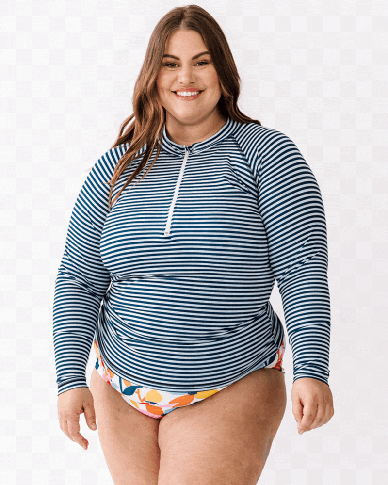 GIF of a woman wearing an Indigo stripe rash guard swim top and a multi color floral swim bottom