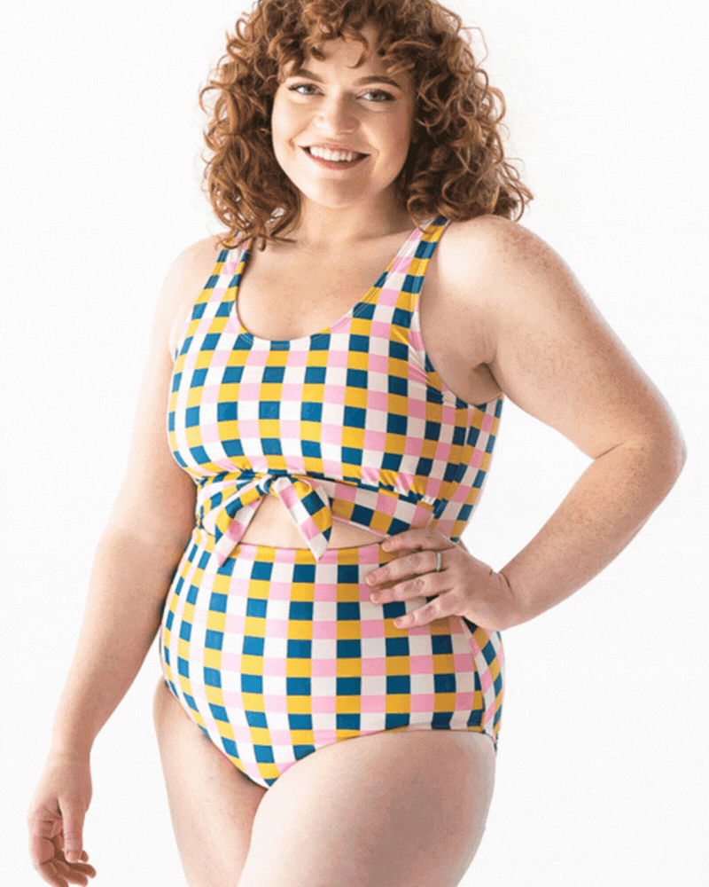 GIF of a woman wearing a multi colored checkered one piece swim suit