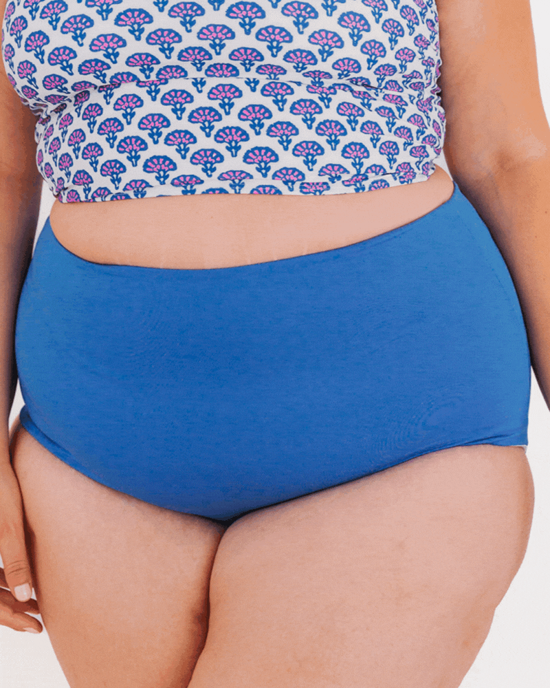 Gif of a woman wearing a Capri/Capri stripe reversible swim bottom and a Block floral swim crop top