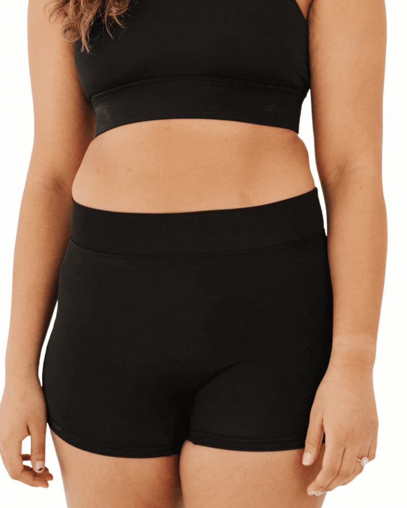 GIF of a woman wearing high-waist black swim shorts