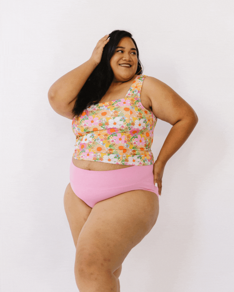 GIF of woman wearing multi colored cropped square neck swim top with pink swim bottoms
