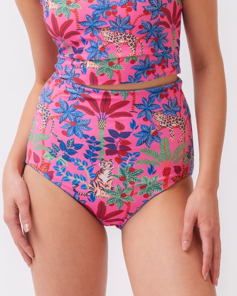 Close up photo of a woman wearing a bold pink print featuring tigers/ blue and pink floral reversible ultra high waist swim bottoms- tiger side