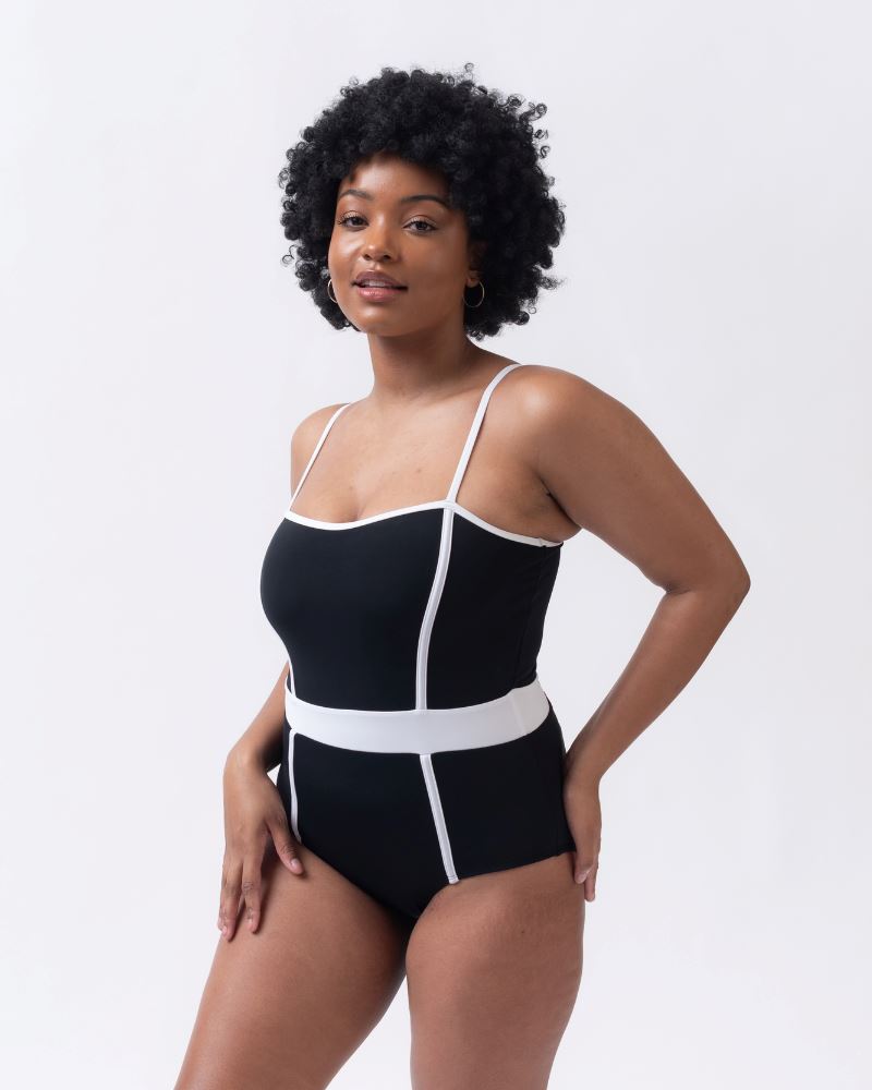 Photo of woman wearing a black and white classic one piece swim suit