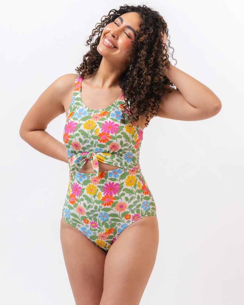 Photo of a woman wearing a multi colored floral knotted one piece swim suit