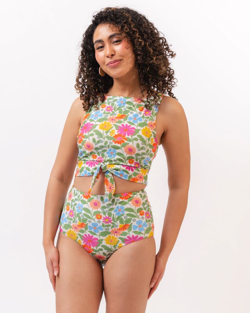 Photo of a woman wearing a multi colored floral cropped swim top with multi colored floral high waist swim bottoms