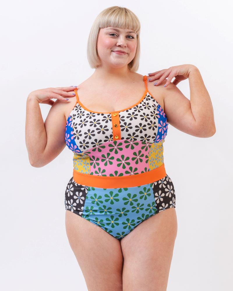 Photo of a woman wearing a multi-colored floral one-piece swimsuit