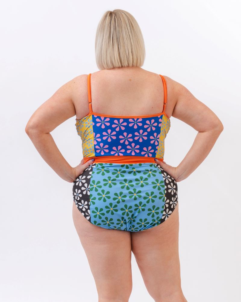 Photo of a woman wearing a multi-colored floral one-piece swimsuit- back angle