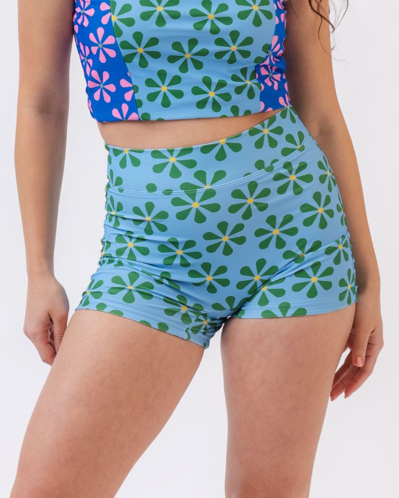 Close-up photo of a woman wearing a blue and green floral swim short bottom