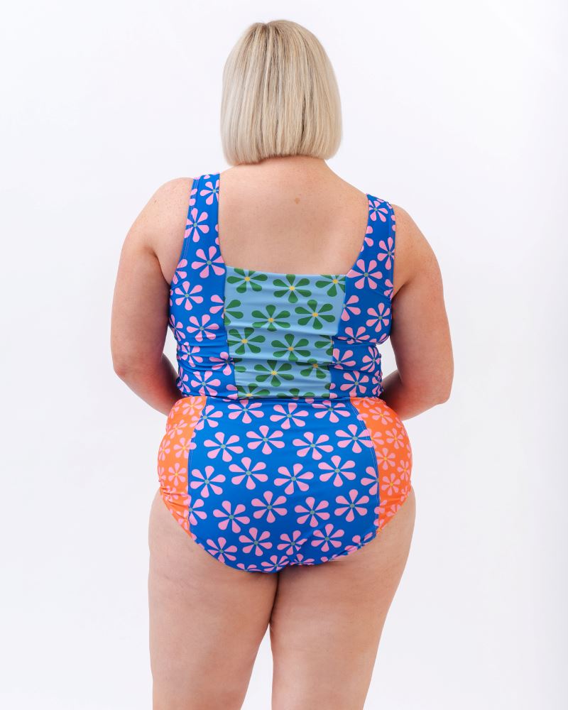 Photo of a woman wearing a multi-colored floral high-waist swim bottom and a multi-colored floral swim crop top- back angle