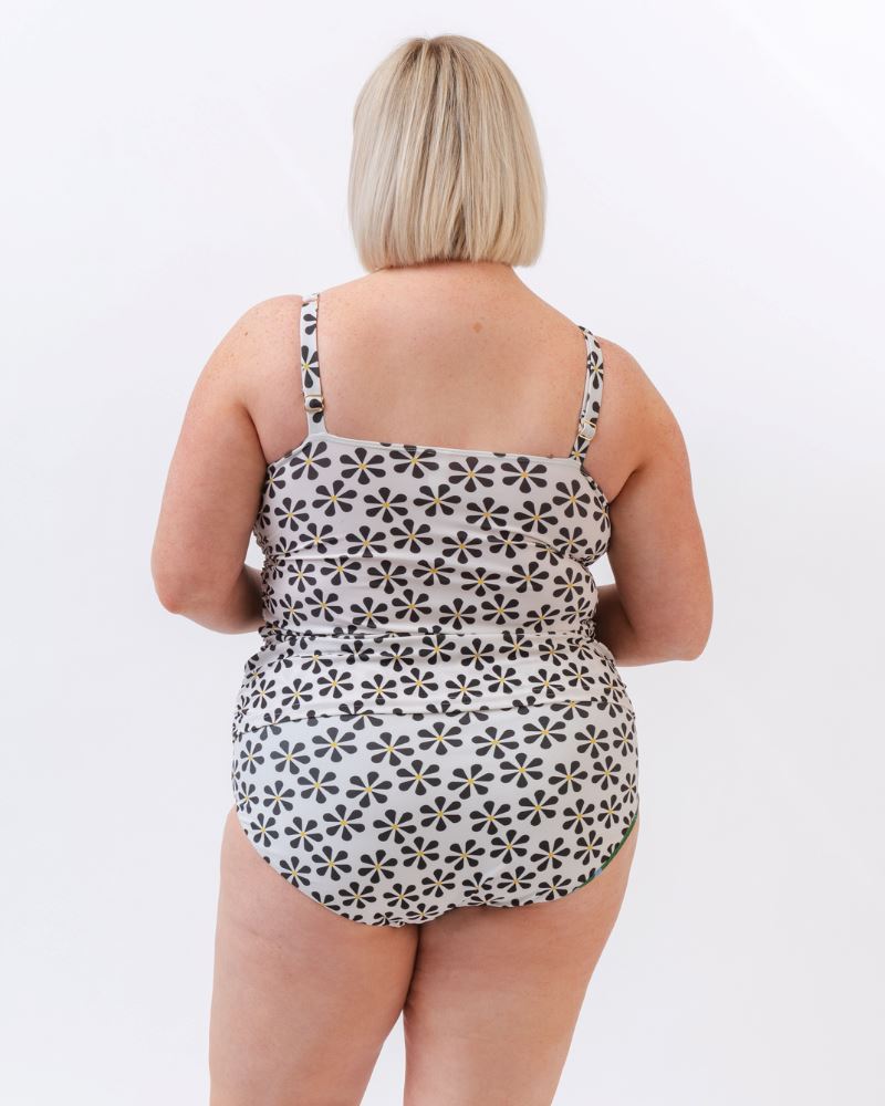 Photo of a woman wearing a black and white floral square neck swim top and a black and white floral swim bottom- back angle