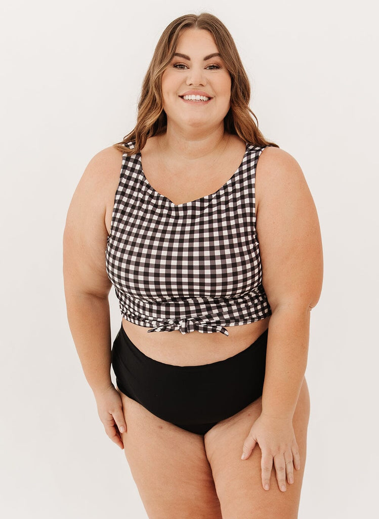 Photo of a woman wearing a black gingham knotted swim crop top with black swim bottoms