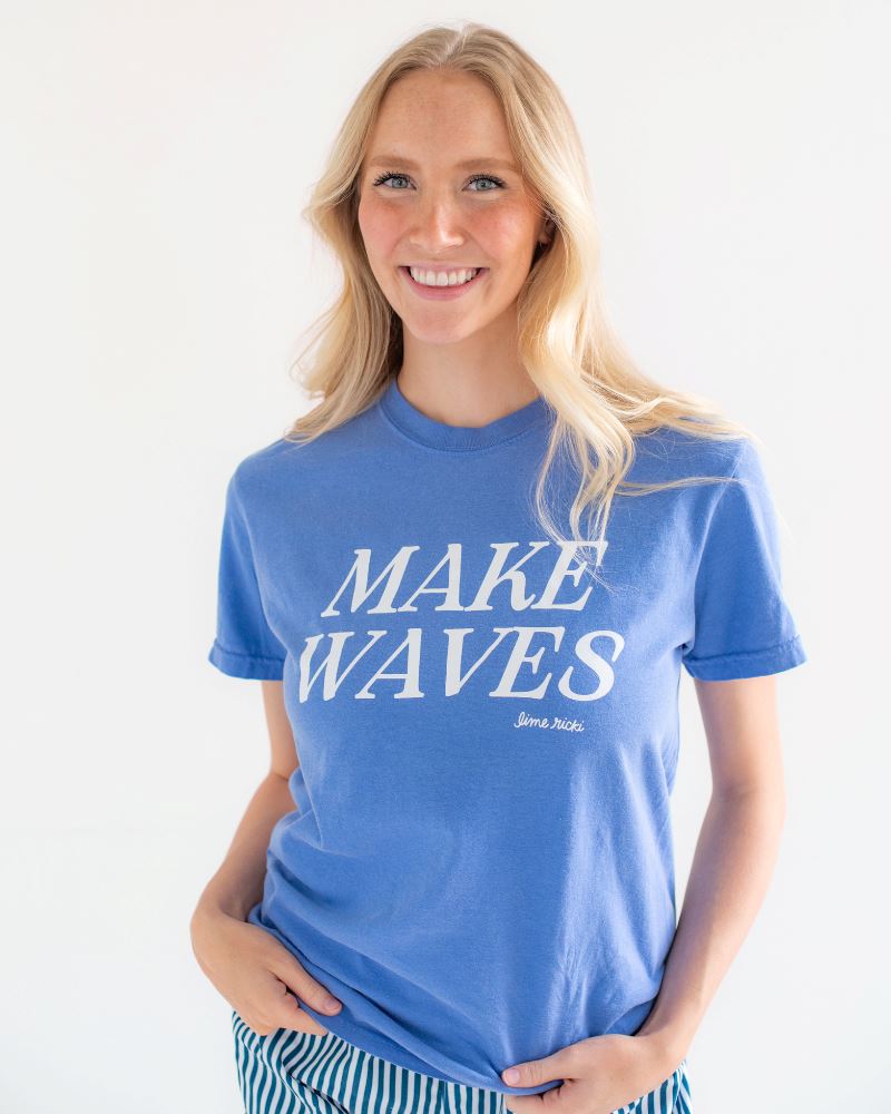 Photo of woman smiling wearing our blue makes waves t-shirt