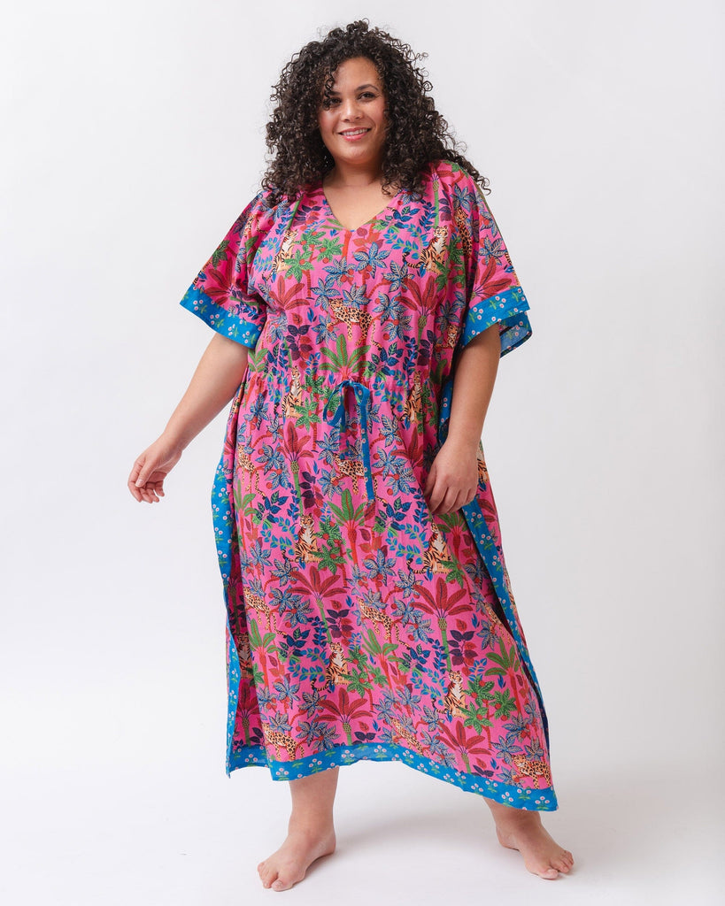 Photo of a woman wearing a bold pink and blue print featuring tigers and leopards caftan swim suit cover-up