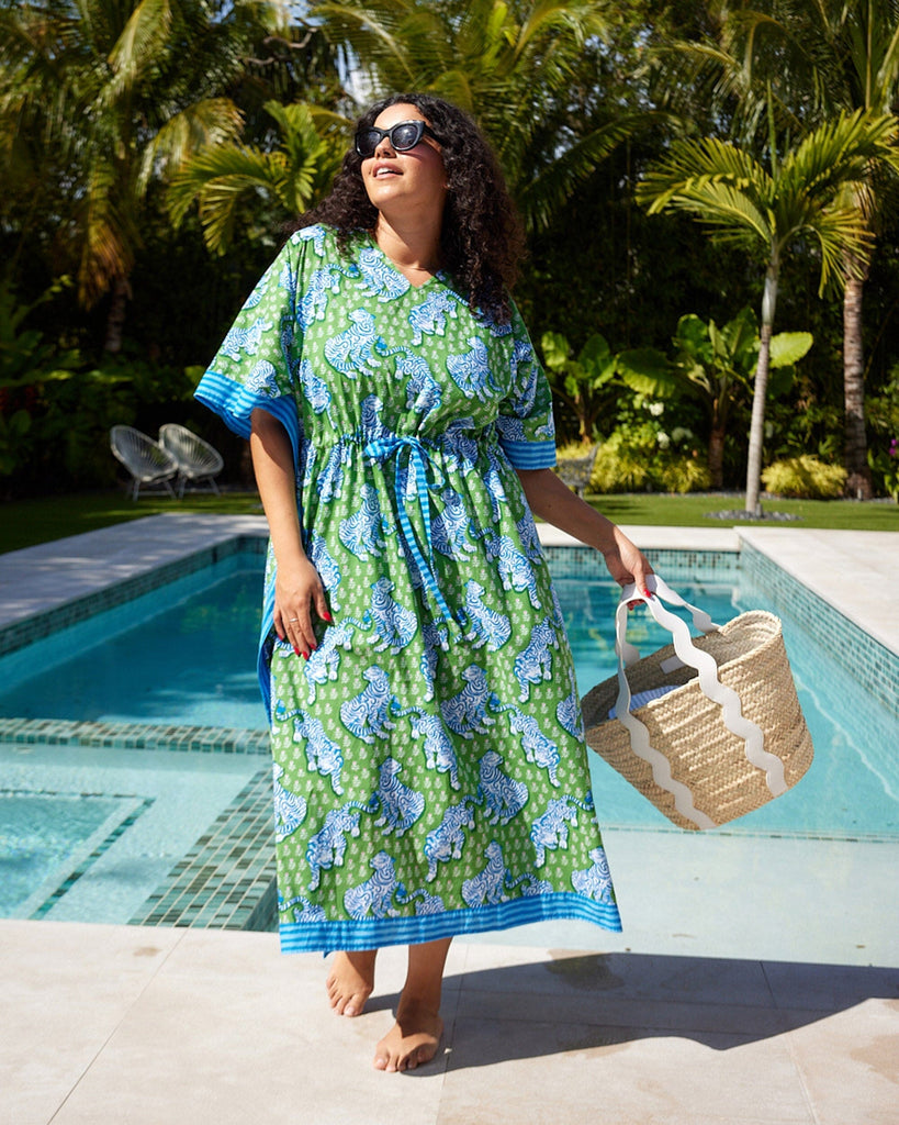 Photo of a woman at the pool wearing a bold green tiger print long cover up