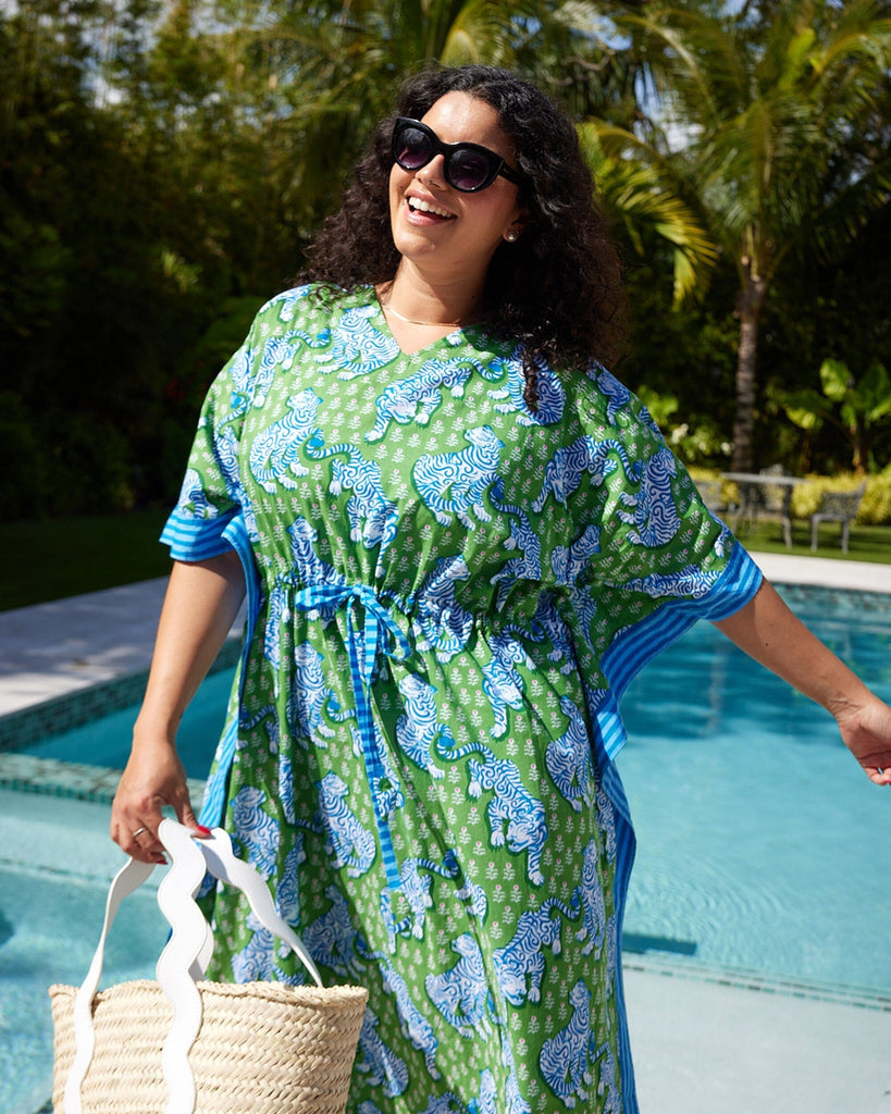 Close up photo of a woman at the pool wearing a bold green tiger print long cover up