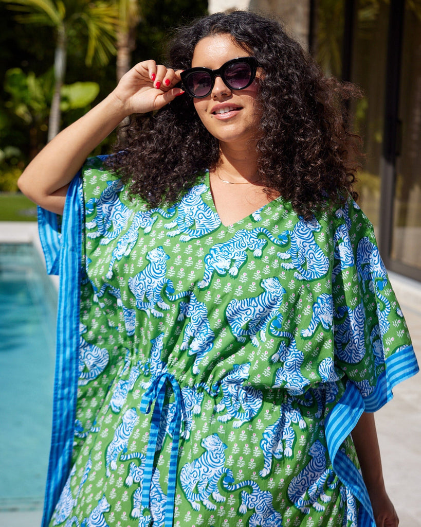 Close up photo of a woman at the pool wearing a bold green tiger print long cover up