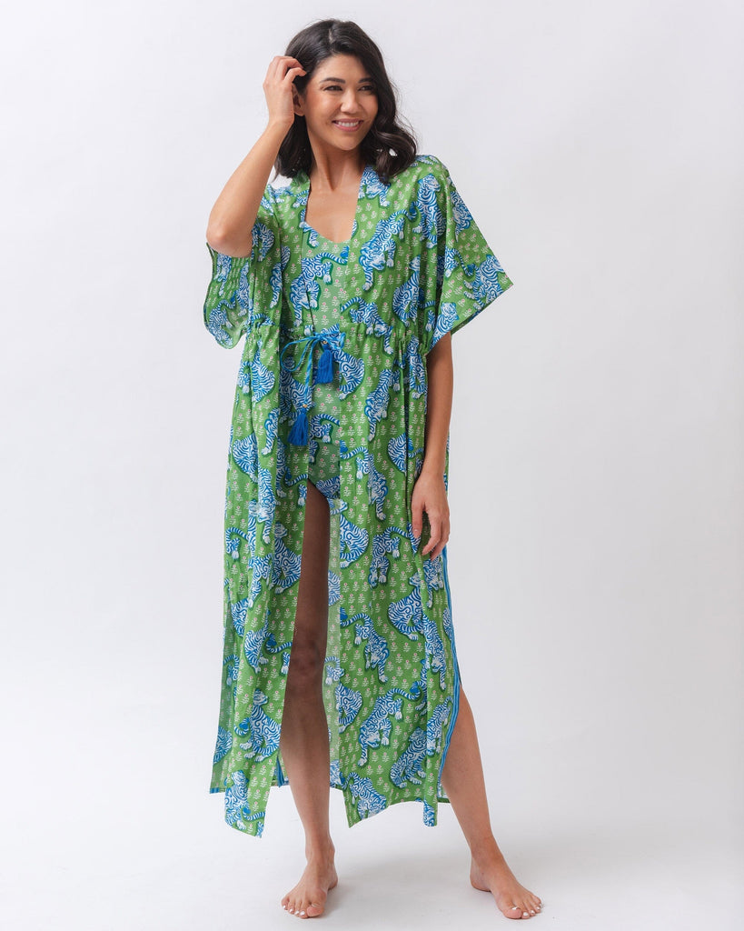 Photo of a woman wearing a bold green tiger print long cover up with a bold green and pink tiger print swim one piece underneath