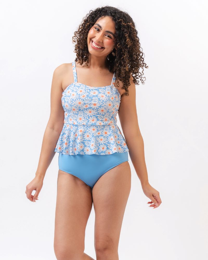 Photo of a woman wearing a blue floral tankini swim top with light blue high waist swim bottoms