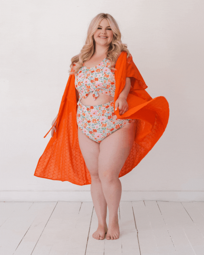 GIF Of a woman wearing an orange Kaftan Cover-Up and a floral swim suit