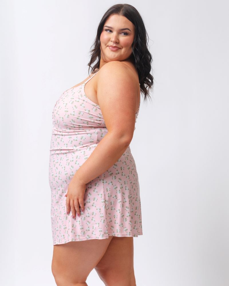 Photo of a woman wearing a pink floral swim dress- side angle
